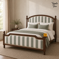 Sage Stripe Arched Teak Bed, lifestyle view with a removable Tapple Tree tag resting on the bed and a small corner logo